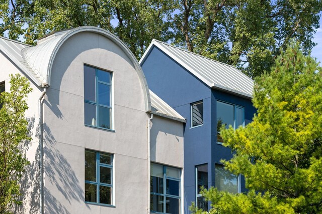 view of property exterior featuring a standing seam roof, metal roof, and stucco siding