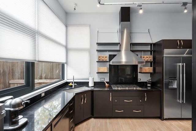 kitchen with a sink, appliances with stainless steel finishes, open shelves, light wood finished floors, and island exhaust hood