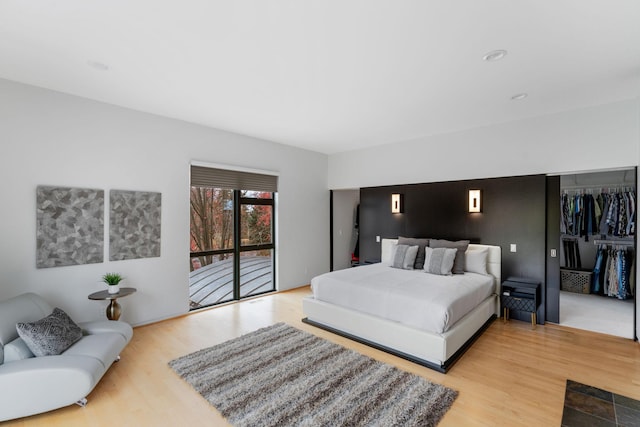 bedroom with access to outside and wood finished floors