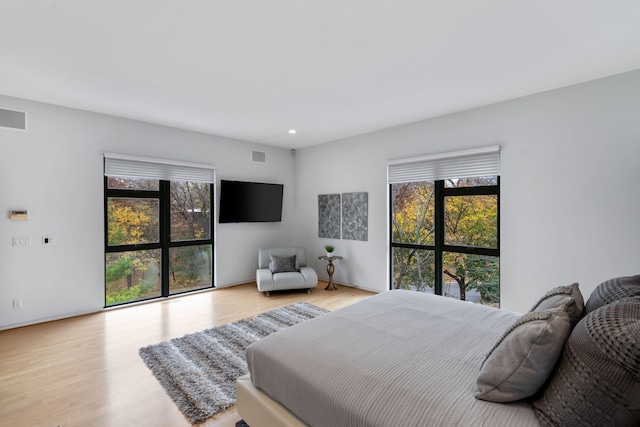 bedroom featuring wood finished floors, visible vents, and recessed lighting