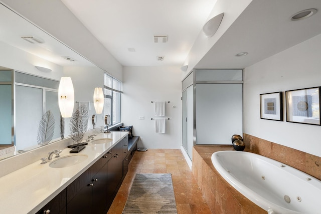 full bathroom featuring double vanity, a tub with jets, a sink, and a shower stall