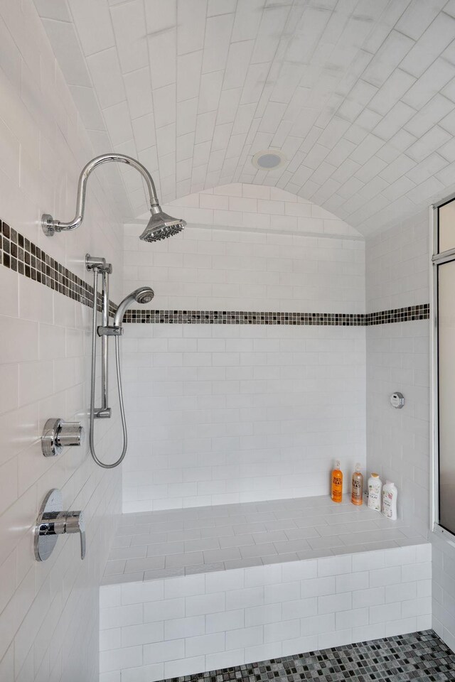 bathroom with vaulted ceiling and a tile shower