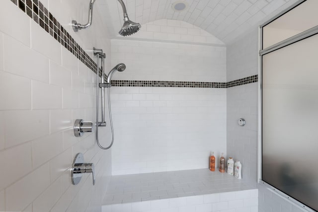 full bath with vaulted ceiling and a tile shower