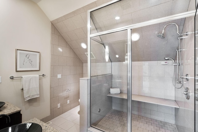 bathroom featuring a stall shower, tile patterned flooring, lofted ceiling, and vanity