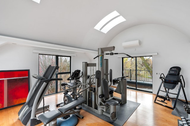 exercise area featuring hardwood / wood-style flooring, plenty of natural light, and an AC wall unit