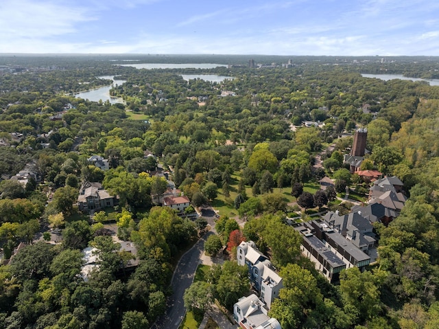 drone / aerial view featuring a water view and a wooded view