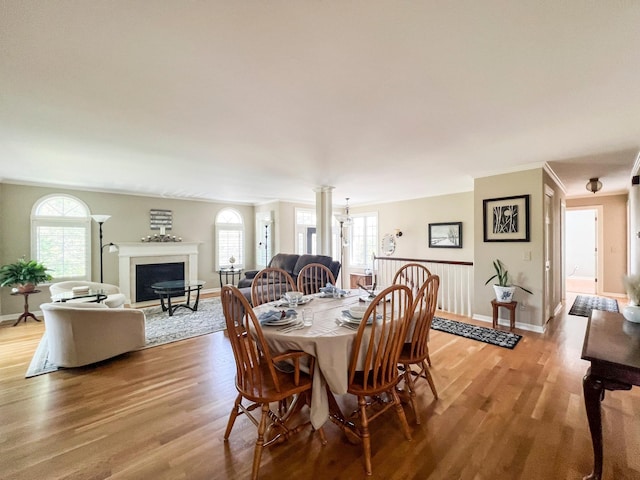 dining space featuring crown molding and light hardwood / wood-style flooring