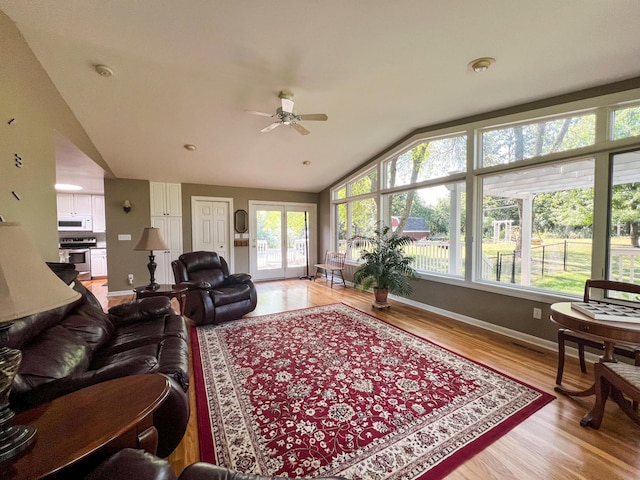 living room with ceiling fan, lofted ceiling, and light hardwood / wood-style floors