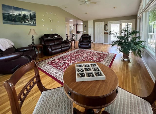 living room featuring ceiling fan, vaulted ceiling, and wood-type flooring