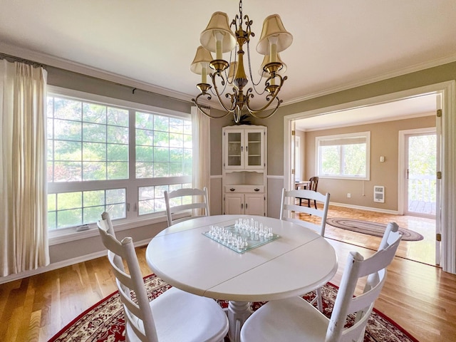 dining room featuring ornamental molding, a chandelier, and light wood-type flooring