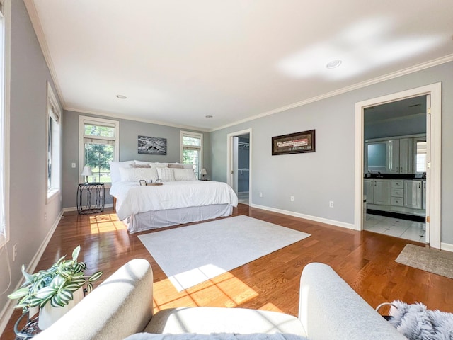 bedroom featuring crown molding, connected bathroom, and hardwood / wood-style floors