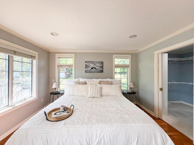 bedroom with multiple windows, wood-type flooring, and ornamental molding