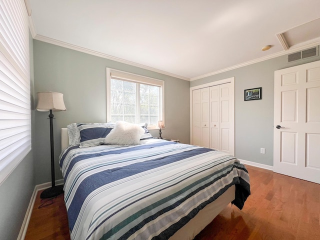 bedroom with ornamental molding, dark hardwood / wood-style flooring, and a closet