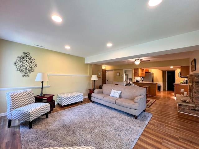 living room with ceiling fan and dark hardwood / wood-style flooring