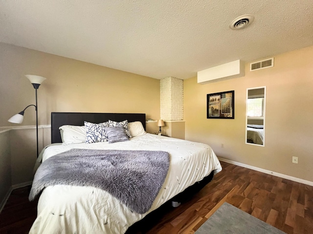 bedroom with dark hardwood / wood-style flooring and a textured ceiling