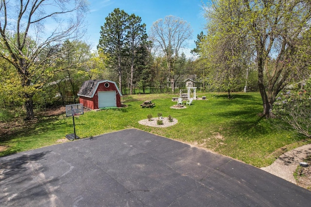 view of yard with a garage and an outbuilding