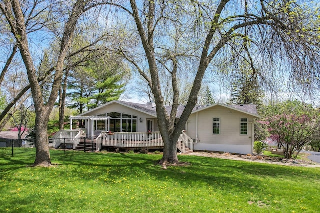 view of front facade featuring a wooden deck and a front lawn