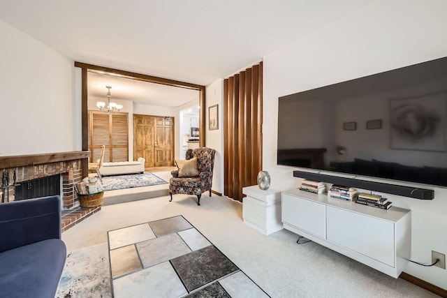 living room featuring carpet flooring, a brick fireplace, and a notable chandelier