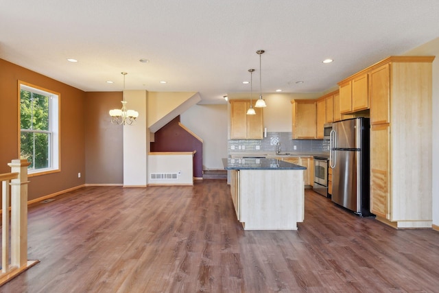 kitchen featuring sink, hanging light fixtures, a center island, stainless steel appliances, and light brown cabinets