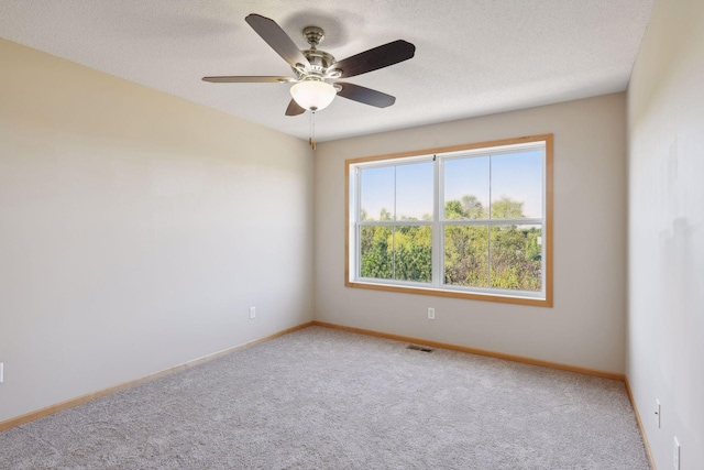 carpeted spare room with ceiling fan and a textured ceiling