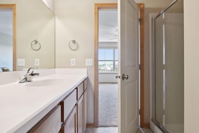 bathroom with vanity and a shower with door