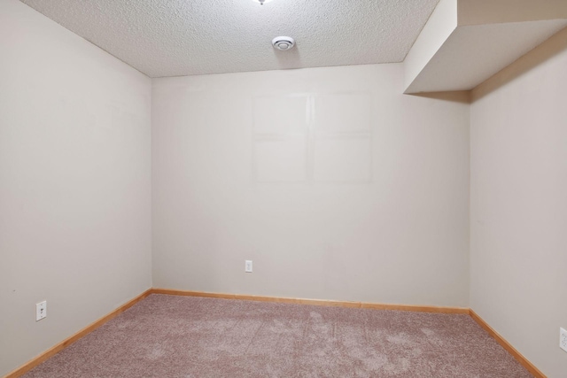 carpeted empty room featuring a textured ceiling