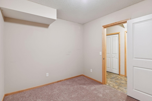 unfurnished room featuring light colored carpet and a textured ceiling