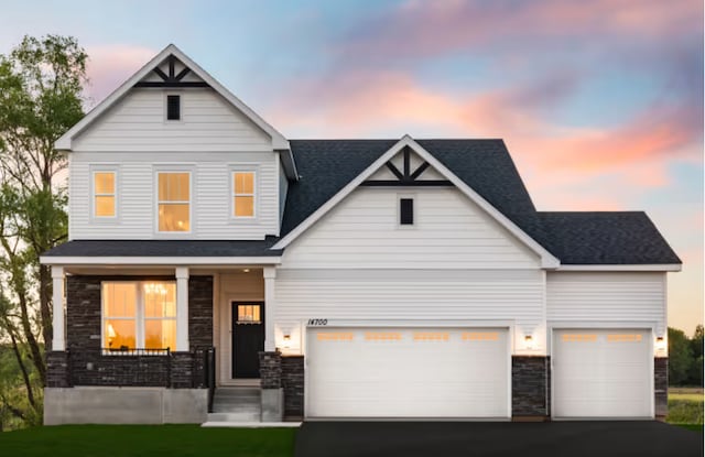 view of front of house with a garage, a lawn, and a porch