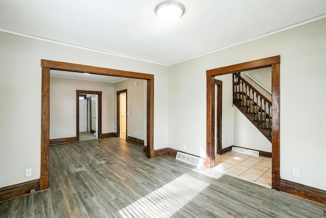 spare room with wood-type flooring and ornamental molding