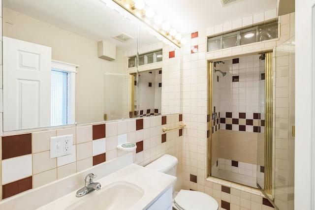 bathroom featuring tile walls, backsplash, an enclosed shower, vanity, and toilet