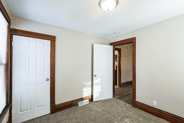 unfurnished bedroom featuring dark colored carpet