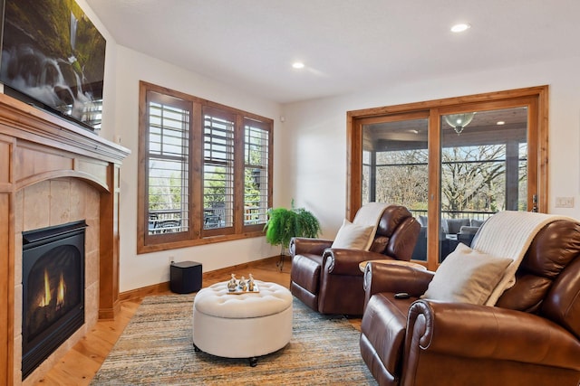 living area featuring light wood-type flooring and a fireplace