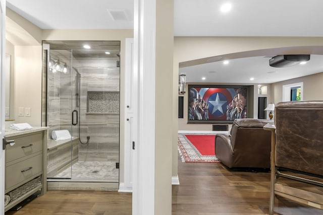 bathroom featuring vanity, wood-type flooring, and walk in shower