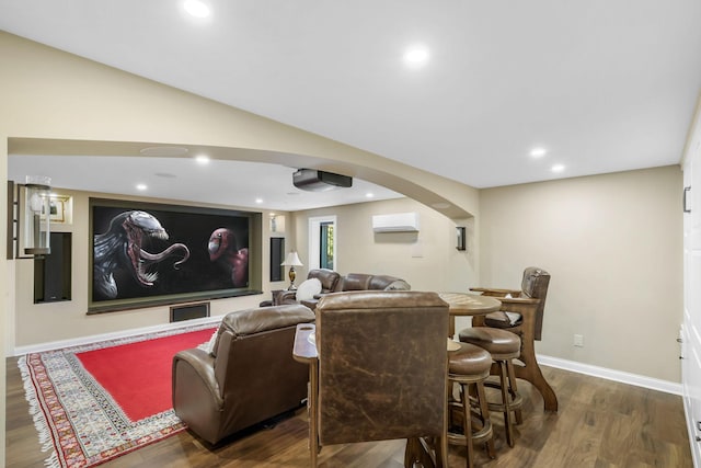 cinema room with lofted ceiling, a wall mounted air conditioner, and dark hardwood / wood-style floors