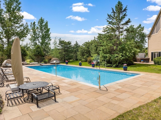 view of pool featuring a lawn and a patio