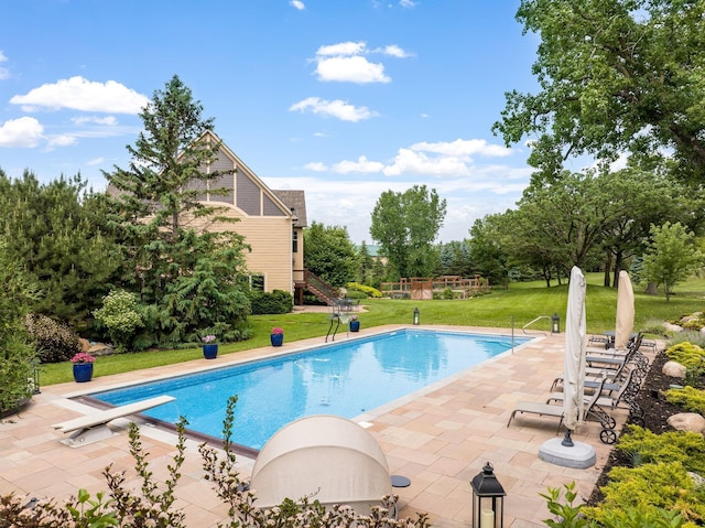 view of swimming pool featuring a diving board, a patio, and a lawn