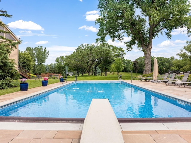 view of pool featuring a yard, a diving board, and a patio