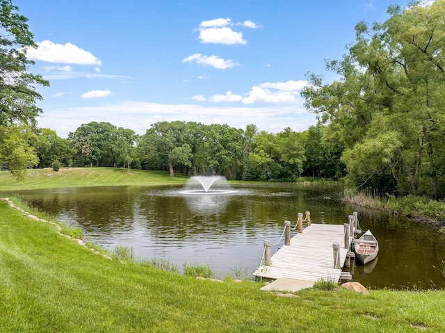 view of dock with a water view and a lawn