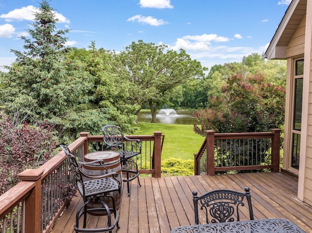 wooden deck featuring a water view and a lawn