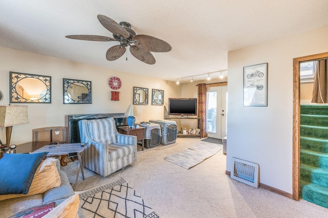 carpeted living room with ceiling fan, rail lighting, and a textured ceiling