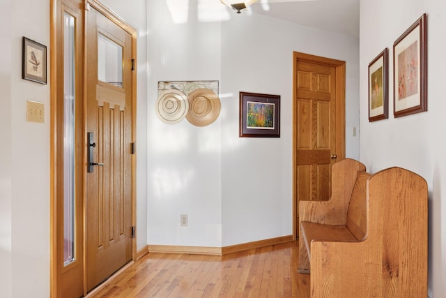hall featuring light wood finished floors and baseboards