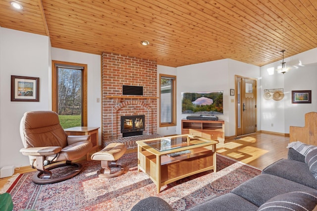 living room with baseboards, wood ceiling, wood finished floors, and a fireplace