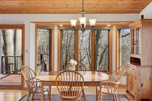 dining room with baseboards, an inviting chandelier, wooden ceiling, and light wood finished floors