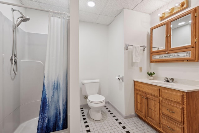bathroom with toilet, curtained shower, tile patterned flooring, vanity, and a paneled ceiling