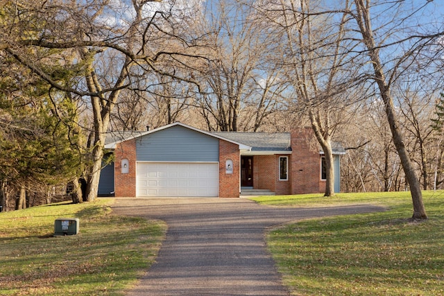 ranch-style house featuring an attached garage, brick siding, driveway, and a front lawn