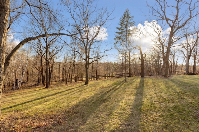 view of yard with fence and a view of trees