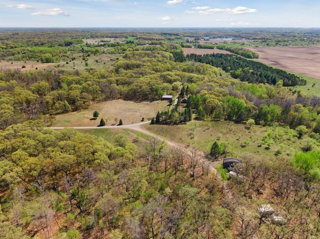 aerial view of property and surrounding area with a heavily wooded area