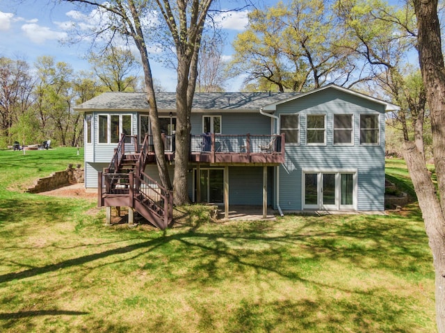 back of house featuring stairs, a wooden deck, and a lawn