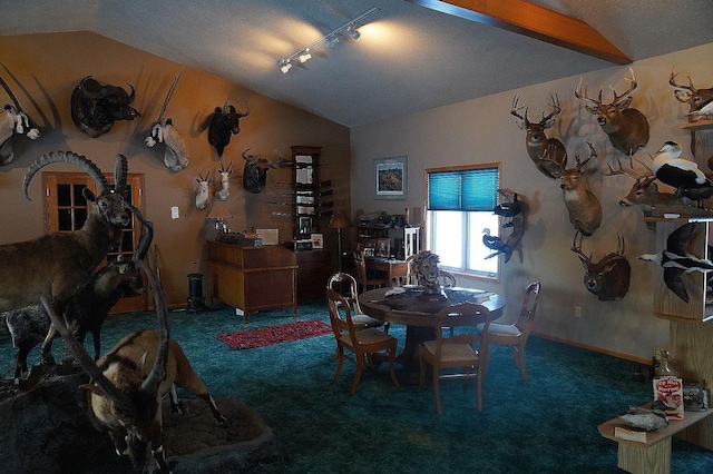 dining space with lofted ceiling, track lighting, and dark carpet