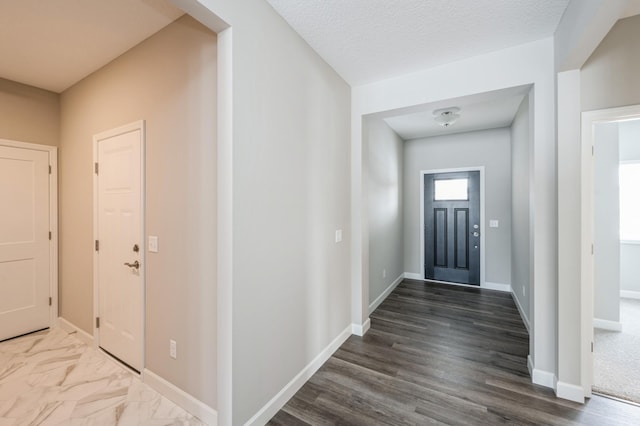 foyer entrance with a textured ceiling